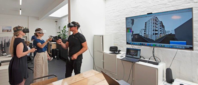 Pessoas utilizando realidade virtual para visualizar edifícios.