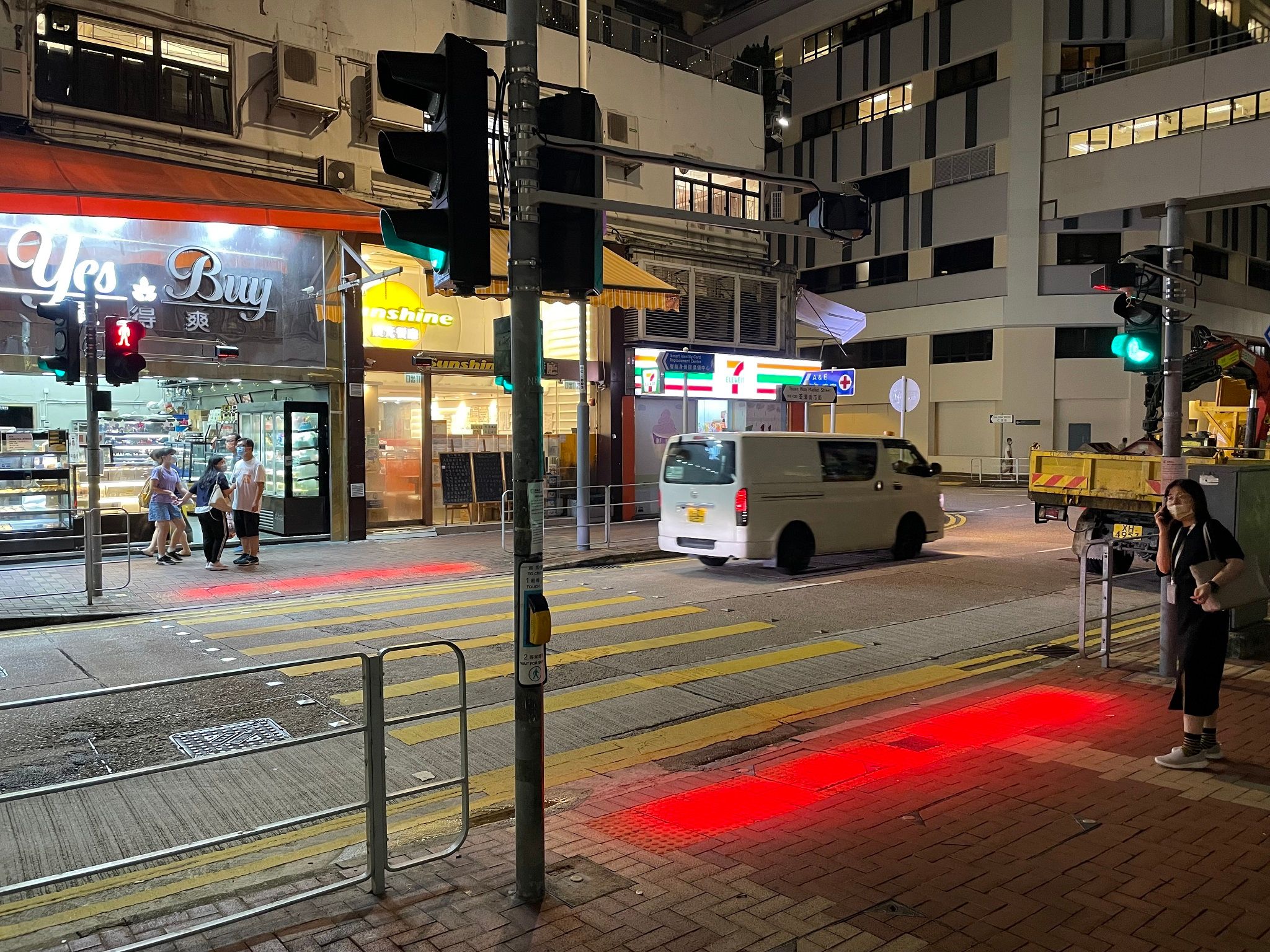 Fotografia de luz auxiliar suspensa sinalizando a calçada, junto da faixa de pedestres.