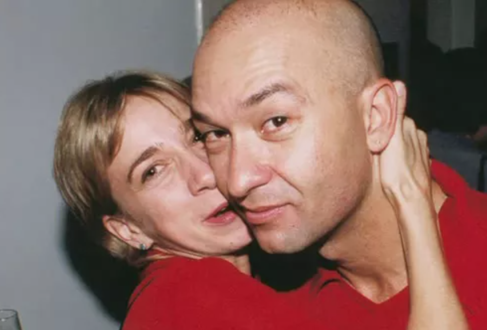 Fotografia de Hebert Vianna e sua esposa, Lucy Needham, abraçados, os dois estão vestidos de vermelho.